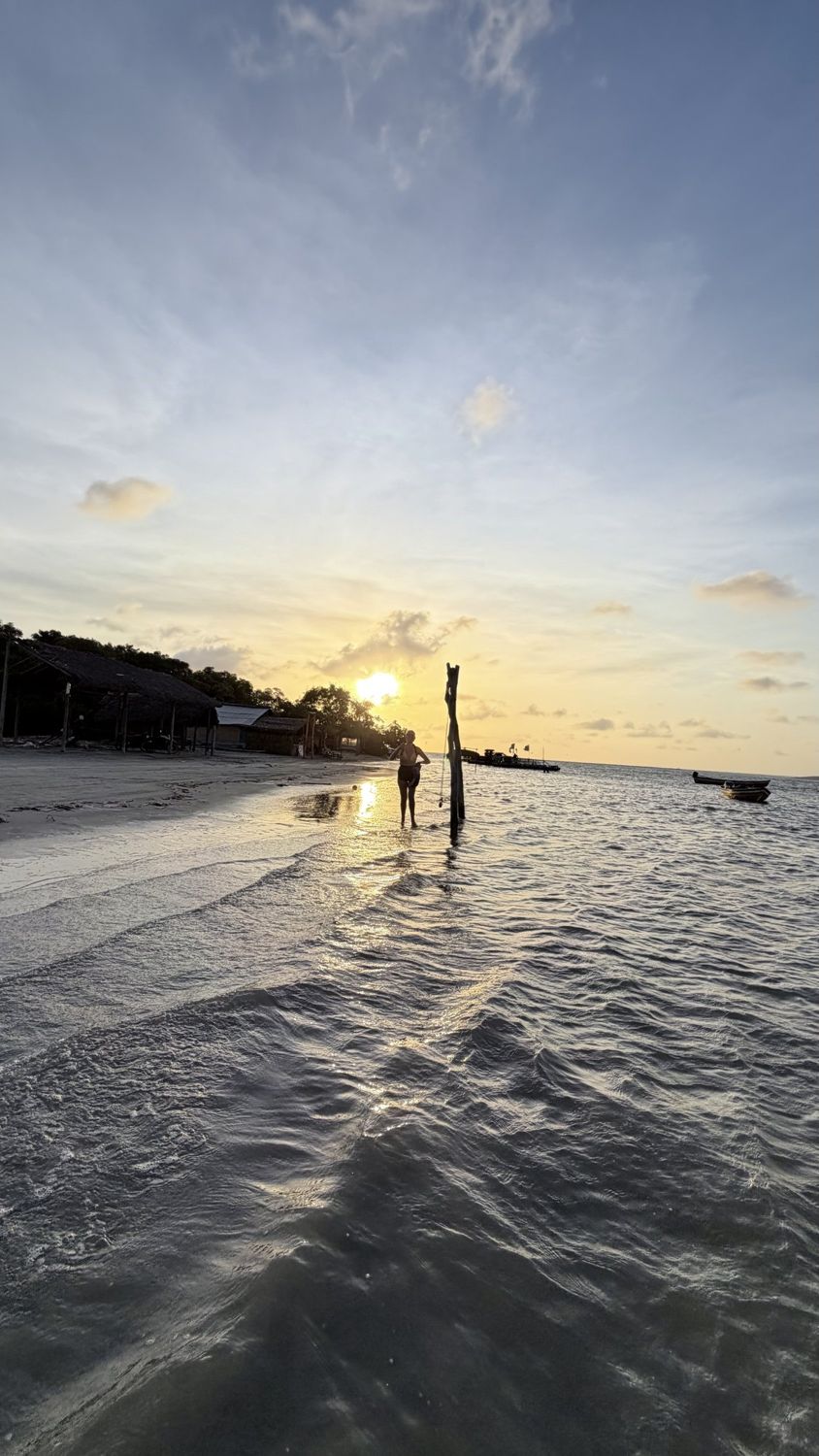 Pôr do sol refletido na água rasa da praia